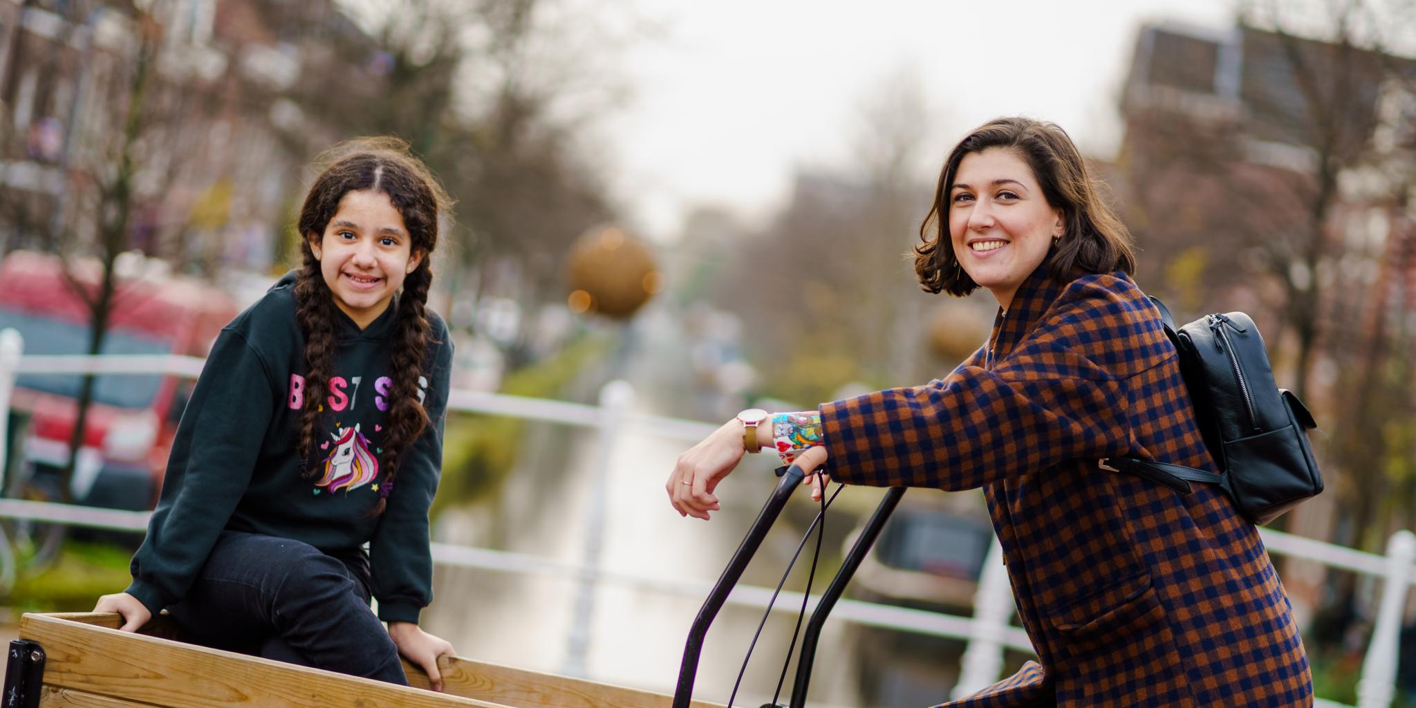Maatjes Nicky en Jasmina fietsen samen waarbij Jasmina voorin de bak zit